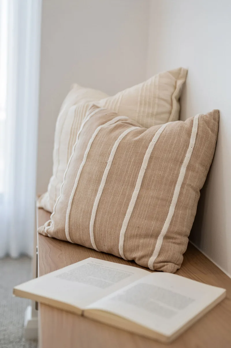 Close detail of layered linen cushions on a styled chair.