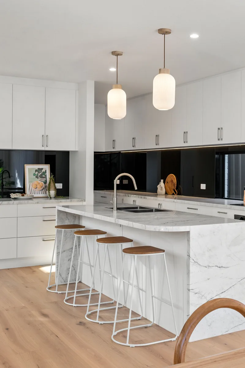 A stone kitchen island styled with stools and accessories.