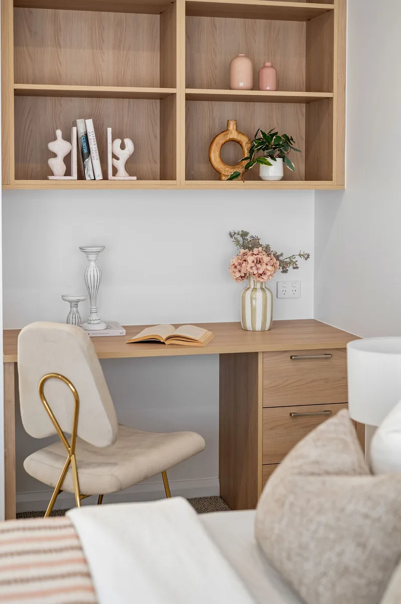 A study nook styled with open shelving, books and flowers.
