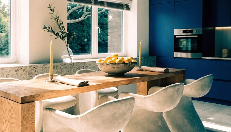 An open-plan dining space styled with a timber table and sculptural chairs.